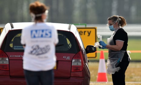 A medical worker tests an NHS worker at a drive-in testing station in Merseyside.