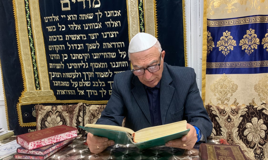 Abram Iskhakov, the president of the Bukhara Jewish Community, reads during an evening service in Bukhara, Uzbekistan.