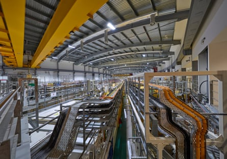 The inside of a large research facility, with long runs of yellow pipes stretching into the distance
