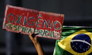 A demonstrator hold poster with a message that reads in Portuguese "Oxygen, Breathe Brazil," during a protest against the government's response in combating COVID-19 and demanding the impeachment of Brazil's President Jair Bolsonaro, in Brasilia, Brazil, Sunday, Jan. 24, 2021. (AP Photo/Eraldo Peres)