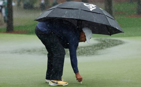 Brooks Koepka marks his ball position on the waterlogged 7th green just before the third round was ended early by the weather.