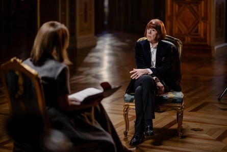 Two woman on chairs in a room with a wooden floor.