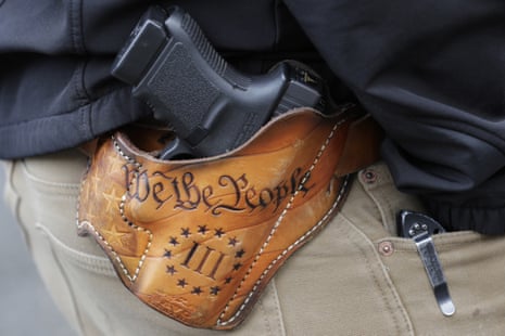 A gun in a holster imprinted with the words "We the People"