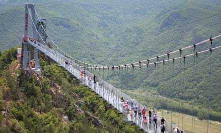 Tourists walk on the glass bridge in Longjing in 2019.
