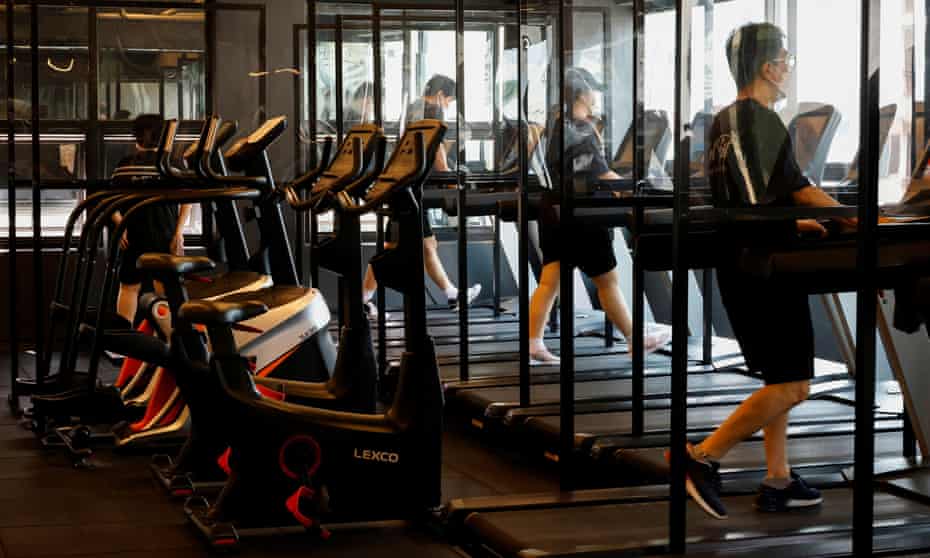Gym members use a treadmill at a fitness club in Seoul