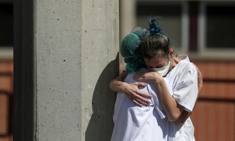 Medical wokers hug each other outside the emergency rooms at Severo Ochoa hospital in Leganes, Spain.