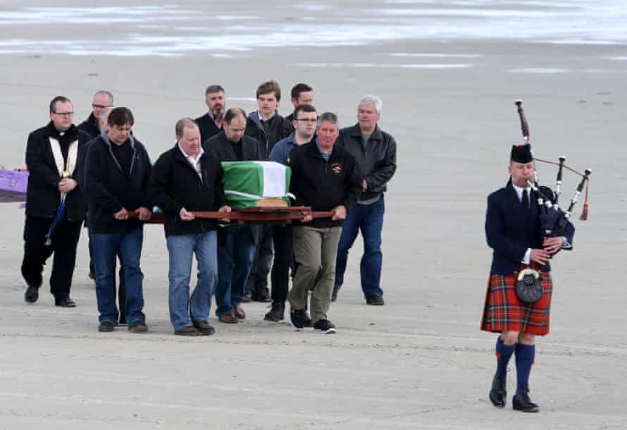 Mourners carry the coffin of Eilidh MacLeod, which is draped with the Barra flag, across Traigh Mhor beach after the body of the 14 year-old was flown home ahead of her funeral.