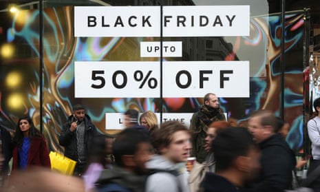 Shoppers pass a sign for a Black Friday sales event on Oxford Street, London, on 24 November 2017