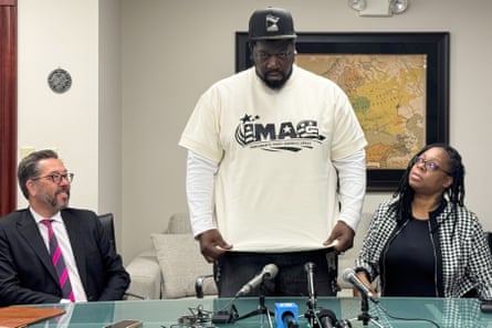 Garrison Gibson, a Liberian man who has lived in the US for about three decades, shows reporters his shirt reading ‘Immigrants make America great’ during a news conference Saturday.