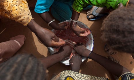 Children share a bowl of porridge in a village in Senegal