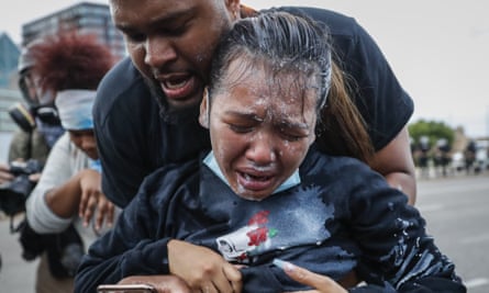 A protester reacts after being hit by pepper spray from police as their group of demonstrators are detained in Minneapolis, Minnesota, on 31 May 2020.