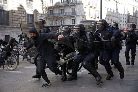 French riot police arrest a protester in a Paris square during a demonstration