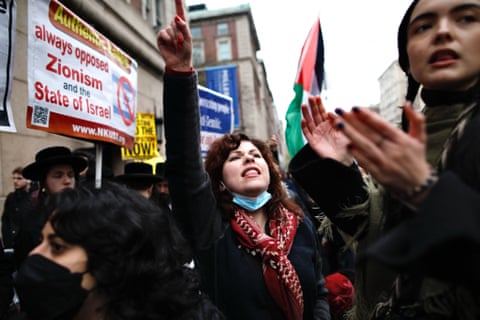 A protester in a crowd raises her hand