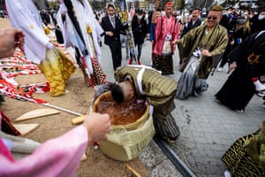 A 20-year-old man (C) puts his head in a sake barrel outside Todoroki Arena during a celebration ceremony to mark “Coming-of-Age Day” to honour people who turn 20 this year to signify adulthood, in Kawasaki, Kanagawa prefecture