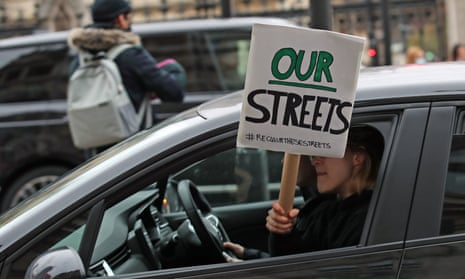 A woman passenger holding a Reclaim these Streets placard in London on 14 March.