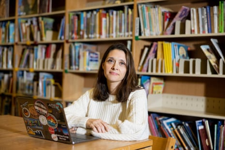A woman sitting at a laptop in a library.