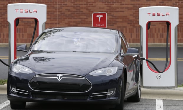 A Tesla car recharges at a charging station at Cochran Commons shopping center in Charlotte, N.C.