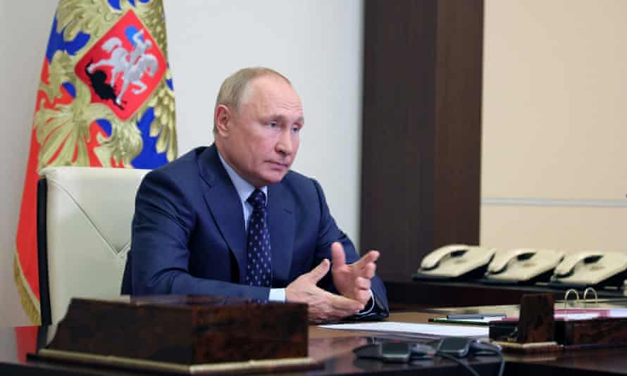 Vladimir Putin attends a meeting with members of the security council via a video link at his residence outside Moscow