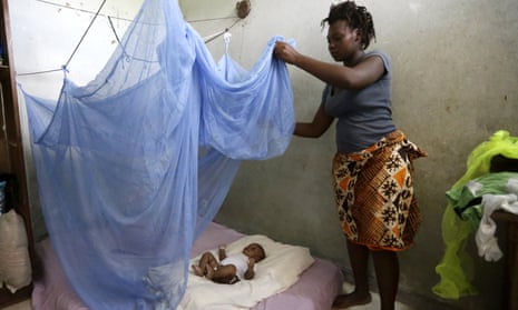 Zamble Lou Irie Sabine  installs a mosquito net on her three-month-old child Yao Melvin, in Abidjan, Ivory Coast.
