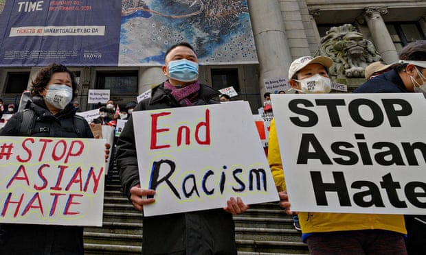 People hold signs at a Stop Asian Hate rally in Vancouver.