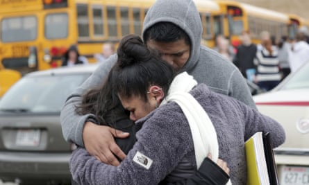 Becky Galvan, center, consoles her daughter, Ashley Galvan, with her father, Jose Chavez, outside Waukesha South high school on Monday.