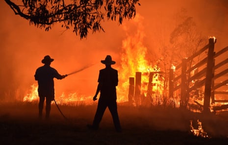 Residents defend a property from a bushfire at Hillsville near Taree, in 2019