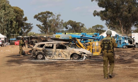Israeli troops inspect the site of the weekend attack on the Supernova desert music festival by Palestinian militants near Kibbutz Re’im