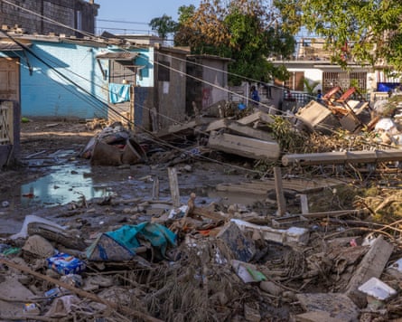 Mud, debris, furniture and people’s belongings piled up outside homes