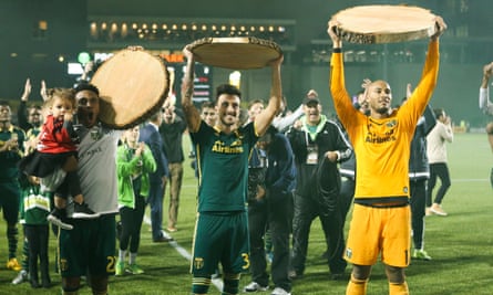 Assorted Portland Timbers players hold up the presentational log slices they won in a match against Kansas City. Yes, log slices.