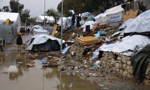 A refugee stands next to a pool of mud at Moria refugee camp on the eastern Greek island of Lesbos