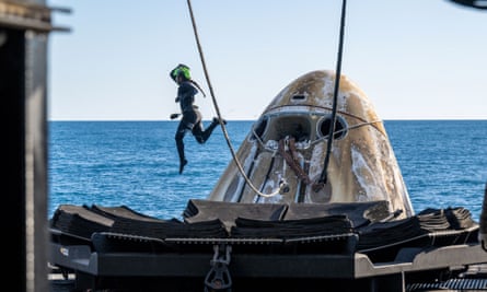 A diver jumps off the capsule after it was lifted on to support vessel.