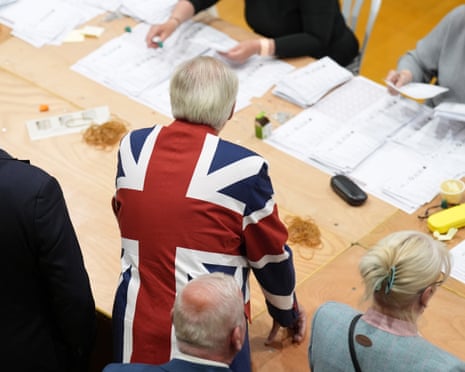 A man in a Union Jack blazer looks on as ballot papers are counted for the Essex County Council election at Clacton Leisure Centre.