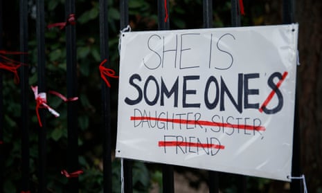 A placard saying 'She is Someone' attached to a fence