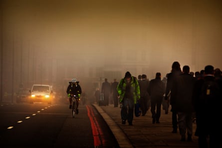 People and traffic crossing a bridge in thick smog