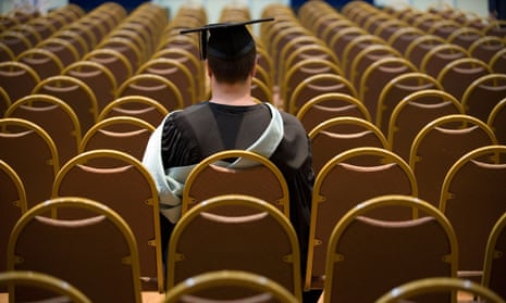 A graduate sitting alone waiting for ceremony to begin.