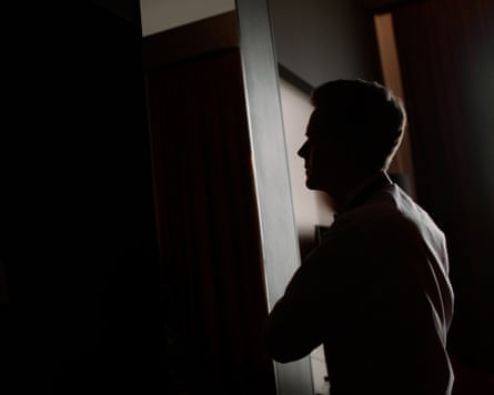 A silhouette of a man standing behind a door