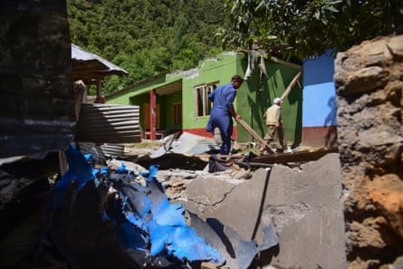 people inspect damage of homes