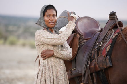 A woman standing by a horse.