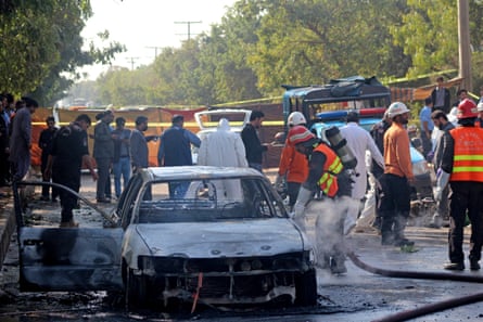 Firefighters douse a bombed car outside the district court buildings