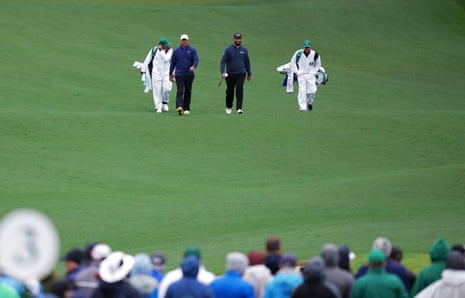 Brooks Koepka and Jon Rahm walk up the 12th.