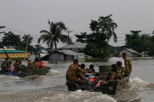 Bangladeshi soldiers head for flooded houses in two small patrol boats