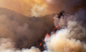 California fires: a helicopter drops water on the Getty fire spreading in the hills behind the Getty Center in Los Angeles.