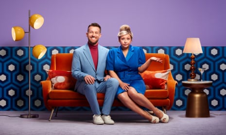 Chris and Rosie – he in a blue suit, her in a blue dress – sit on an orange couch in the second series of The Chris & Rosie Ramsey Show