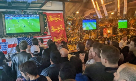 Football fans watching the World Cup game between the USA and England in a New York bar.