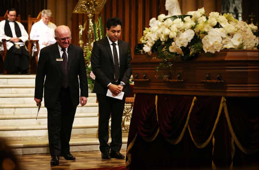 Alpha Cheng stands in front of his father’s casket during his funeral service in October 2015.