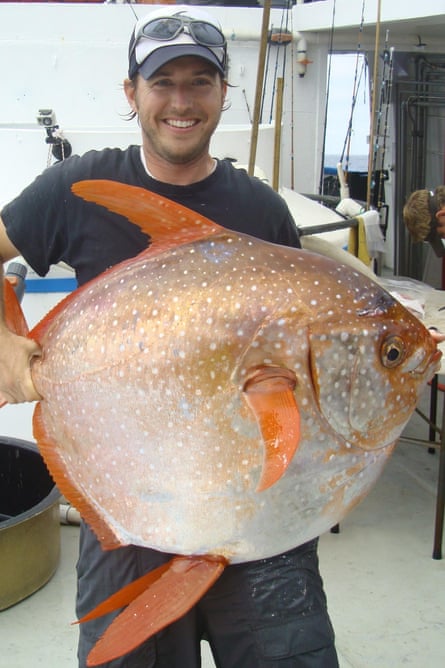 NOAA fisheries biologist Nick Wegner holds an opah caught during a research survey off the California Coast. 