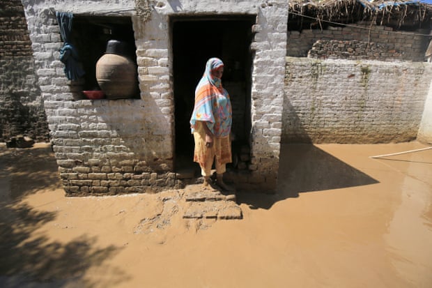 A woman checks her damaged house in the aftermath of floods in Charsadda district, Khyber Pakhtunkhwa province, Pakistan.