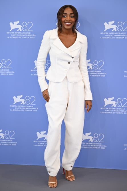 Edebiri in a white trouser suit and heeled sandals
