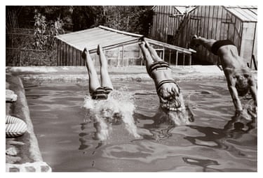 Three kids jump into a pool.