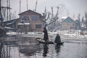 Srinagar, India. A Kashmiri woman rows a boat on Dal Lake after heavy snowfall